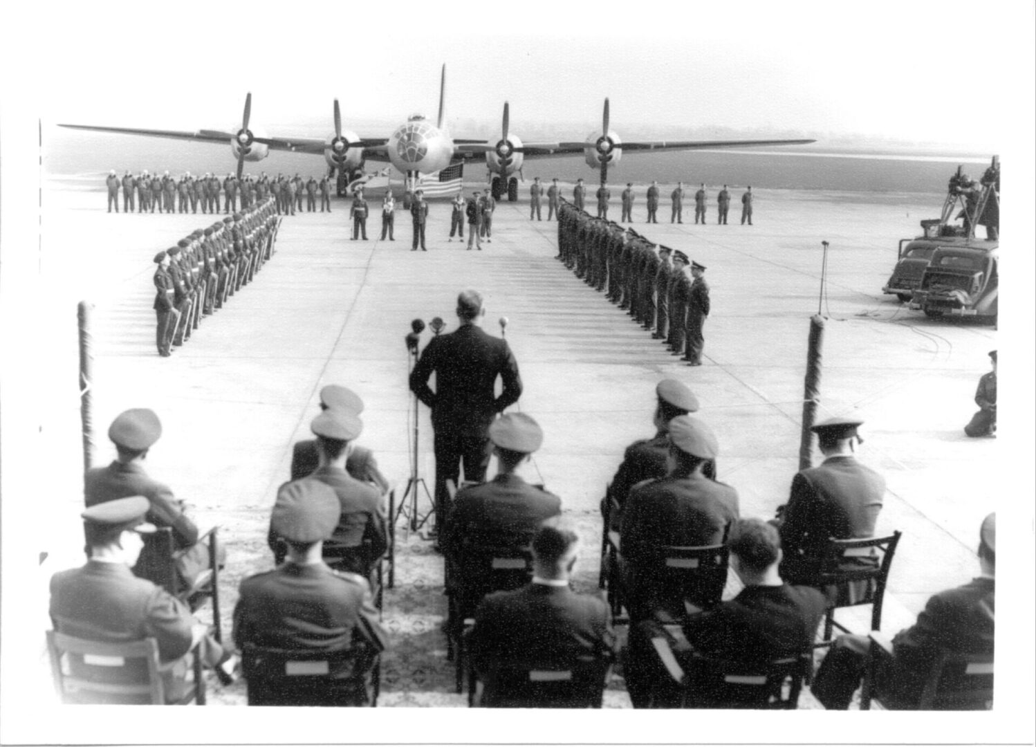 An old image of a plane with soldiers all around
