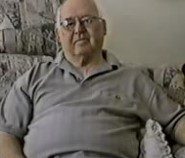 An older man sitting on a couch.