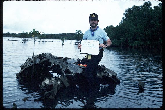 Image of a man holding a board inside the water